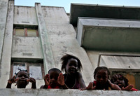 Soviet style bloc apartment with children on the roof - Muputo, MZ