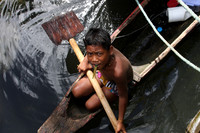 Micronsian boy in a canoe