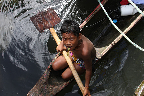 Micronsian boy in a canoe